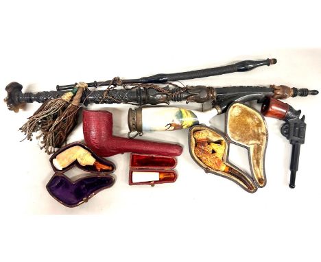 A collection of novelty pipes, one in the shape of lady's leg, a hand holding vase, animal with rifle, etc., together with a 