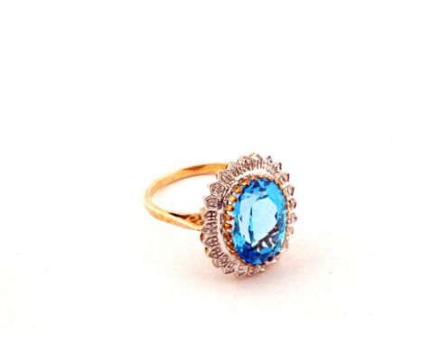 A 9ct Gold ring set with a central blue Topaz with Diamond chips on the surround
