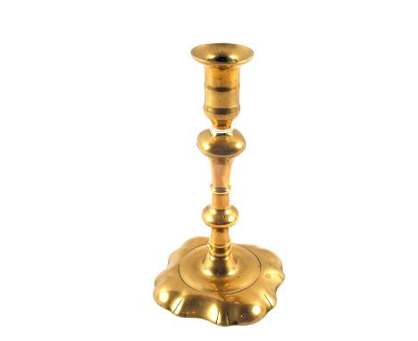 An 18th Century seamed Brass candlestick with knopped stem and petal base, 7 1/2" high