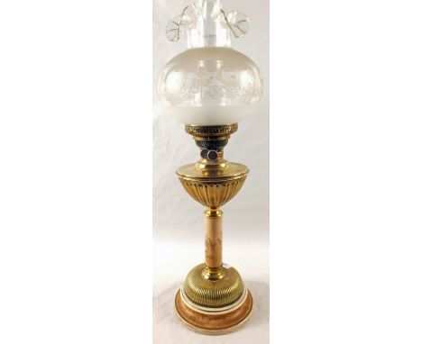 A Brass and pottery oil lamp with moulded globe