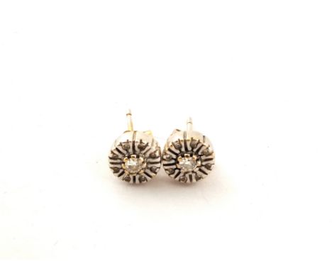 A pair of white metal earrings with a central Diamond and eight small surround Diamonds