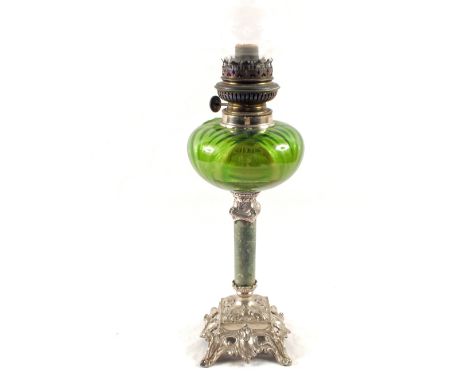 An oil lamp with green glass bowl