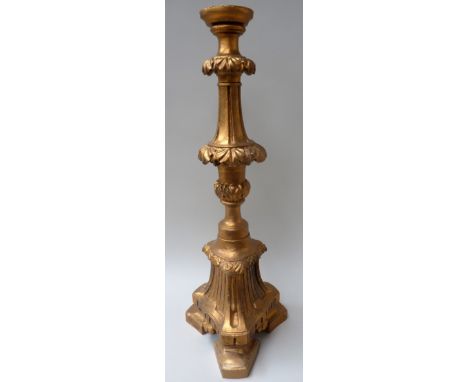 A substantial carved wooden candlestick decorated in gilt carving, 75cmH