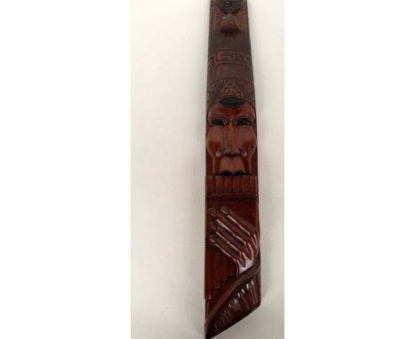 A mahogany Bolivian wall carving of a man with Bolivian hat playing the pan pipes 61cmH