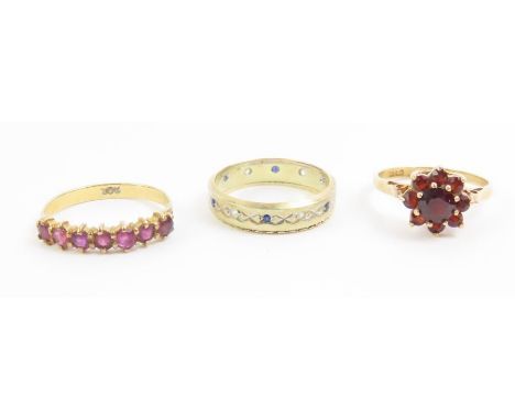 A 9ct gold garnet cluster ring, finger size O, a ruby seven stone ring, marked '9ct', finger size P 1/2, and a 9ct gold blue 