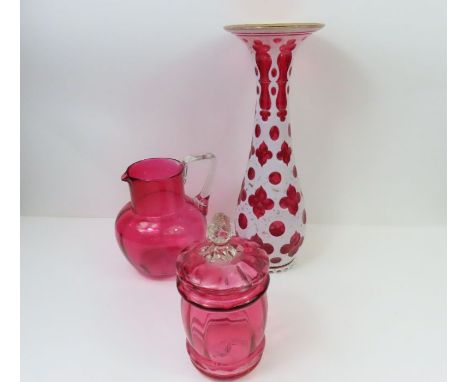 A Victorian white overlay ruby glass vase with gilt rim and detail. 32cms high together with a Victorian cranberry glass jug 