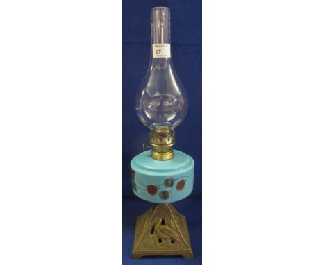Early 20th Century brass single burner oil lamp with painted ceramic reservoir and cast metal base, with clear chimney.