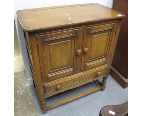 Small Ercol elm two door cupboard, on baluster turned legs.