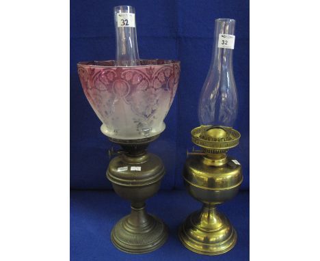 Brass double burner oil lamp with brass reservoir and pedestal base with clear chimney together with another similar, having 