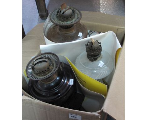 Three early 20th Century oil lamp burners with one funnel together with hand held burner and funnel.