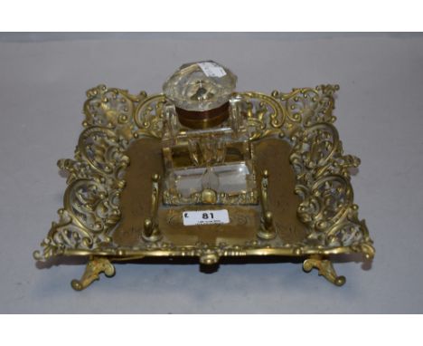 A Victorian cut glass inkwell with ornate brass tray having integrated quill rack.AF.