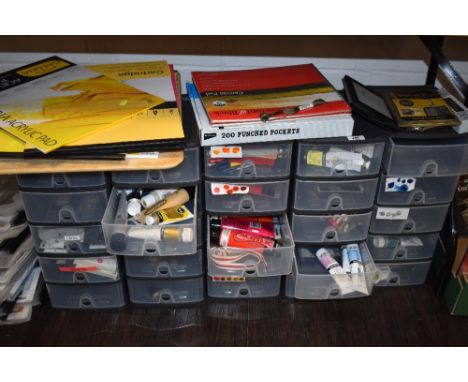 A large collection of art supplies including sketch books, paints and accessories