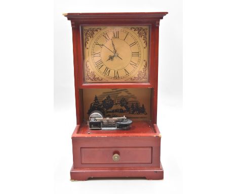 The Mr. Christmas music box and clock come in red with gold-tone accents. The music box comes with seven changeable music dis