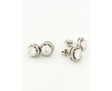Two pairs of white gold and clear round diamond and CZ earrings. One pair is slightly larger than the other. Both have clear 