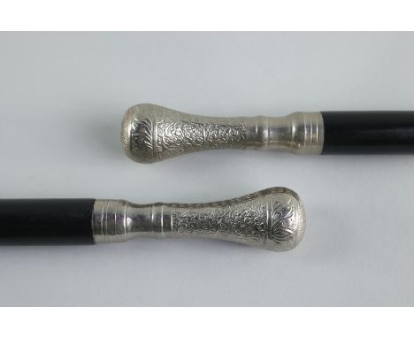 Both walking sticks are black with identical silver handles and tips. The longest is 36 x 1 in. with a 1.25 in diameter x 4.5
