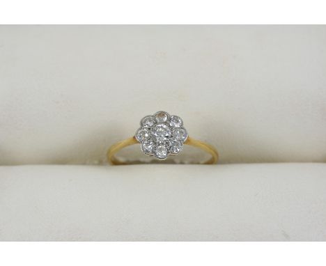 A DIAMOND CLUSTER RING centred with an old brilliant-cut diamond within a surround millegrain set with smaller old brilliant-
