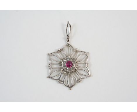 A RUBY AND DIAMOND PENDANT the openwork flower head pendant is centred with a circular-cut ruby within a surround of rose-cut