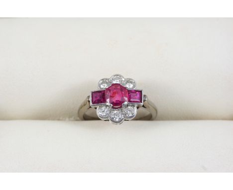 A RUBY AND DIAMOND CLUSTER RING the oval-shaped ruby is set within a surround of two square-cut rubies and six circular-cut d