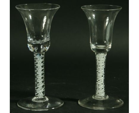 TWO 18TH CENTURY WINE GLASSES, with bell shaped bowls above white enamel double helix stems and spreading feet; and another w