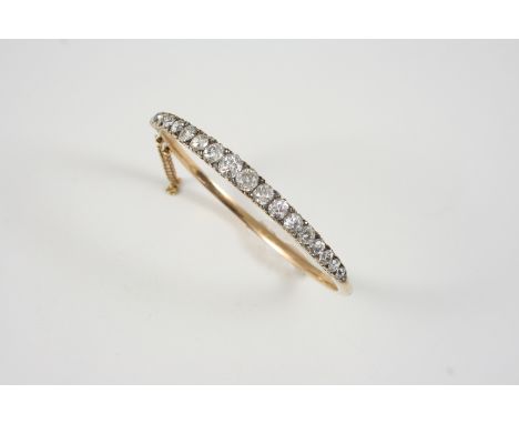 A VICTORIAN DIAMOND AND GOLD HALF HINGED BANGLE set to one side with graduated old brilliant-cut diamonds, with rose-cut diam