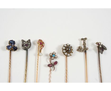 SEVEN ASSORTED GOLD AND GEM SET STICK PINS including one formed as a question mark and set with diamonds, rubies and a pearl,