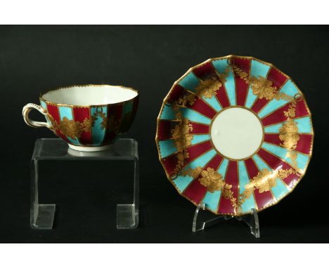 A WORCESTER TEACUP AND SAUCER c. 1770, decorated with alternate turquoise and claret stripes with tooled gilt floral swags. A