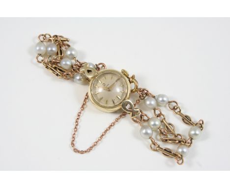 A LADY'S GOLD WRISTWATCH BY OMEGA the signed circular dial with dagger numerals, on a gold bracelet set with cultured pearls,