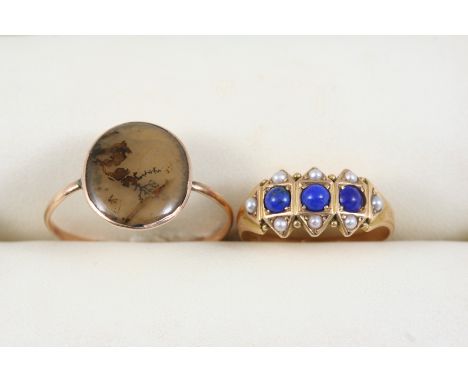 A 15CT. GOLD, LAPIS LAZULI AND PEARL RING centred with three circular lapis lazuli cabochons within a surround of half pearls