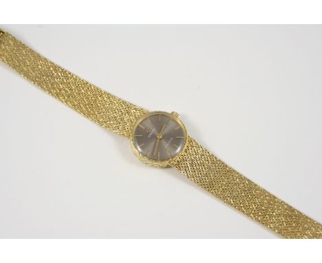 A LADY'S 14CT. GOLD WRISTWATCH BY OMEGA the signed circular dial with baton numerals, on an integrated gold bracelet with lad