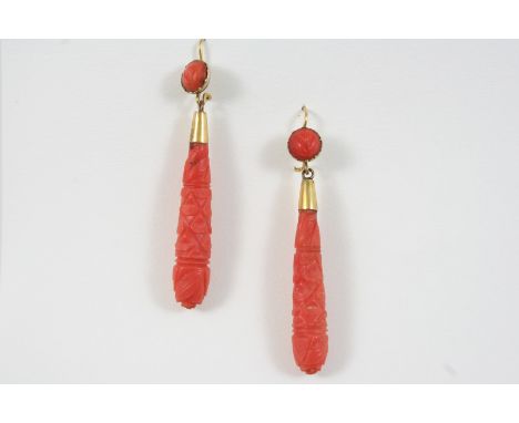 A PAIR OF CORAL DROP EARRINGS each set with a carved coral baton drop, suspended from a circular coral surmount, 5.5cm. long.