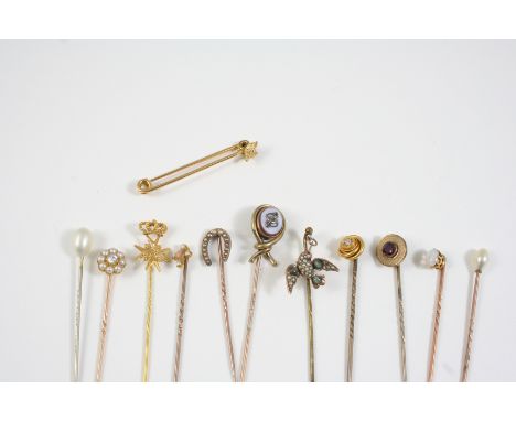 TWELVE ASSORTED GOLD AND GEM SET STICK PINS one formed as a dove and set with small pearls, one set with a cabochon opal, a d