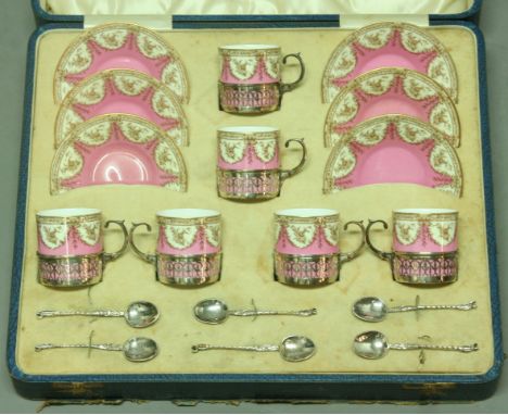 A ROYAL WORCESTER COFFEE SET with printed floral decoration on a pink ground with silver mounts and spoons (cased).