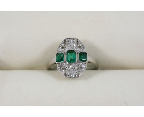 AN EARLY 20TH CENTURY EMERALD AND DIAMOND RING the three graduated rectangular-shaped emeralds are set within a surround mill