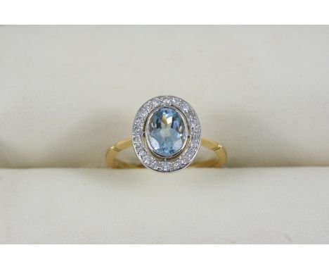 AN AQUAMARINE AND DIAMOND CLUSTER RING the oval-shaped aquamarine is set within a surround of circular-cut diamonds, in 18ct.