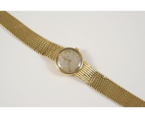 A LADY'S 18CT. GOLD WRISTWATCH BY OMEGA the signed circular dial with baton numerals, on an integrated gold bracelet, 36 gram