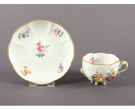 TASSE MIT UNTERTASSE, Asthenkel und -füße, auf der Wandung plastische Blumen, farbig und gold staffiert, innen gemalte Streub