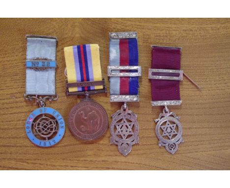 An Edwardian silver gilt and enamel Masonic medal; together with two other silver examples; and a North African Service medal