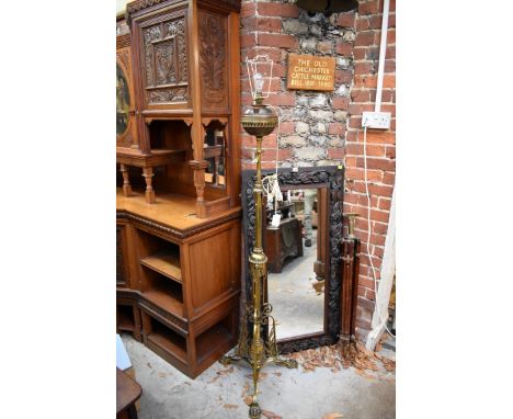An antique brass adjustable tripod standard lamp. 