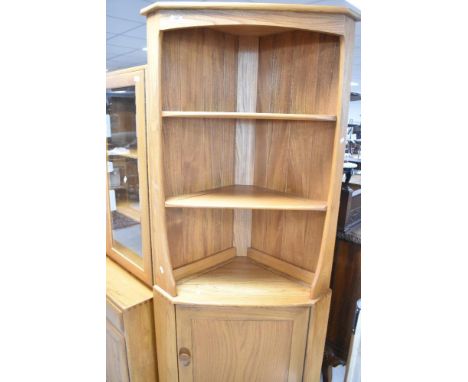 An Ercol 'golden dawn' style corner shelf having cupboard under, height approx. 180cm