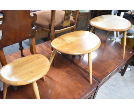 A nest of three Ercol pebble style tables, width approx. 65cm, badge to underside of large table