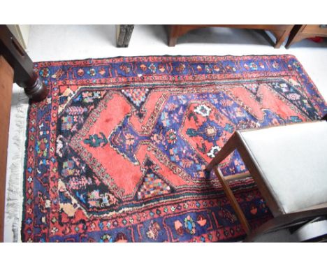 A traditional wool persian style rug, approx. 215 x 132cm