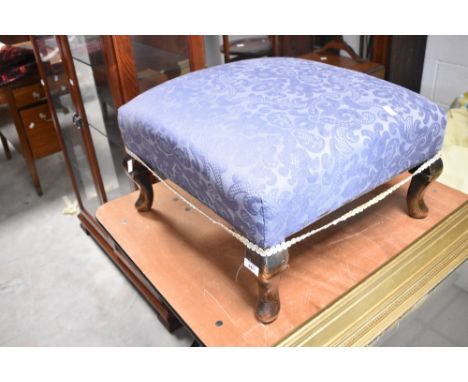 An early 20th century footstool having blue upholstery and cabriole legs