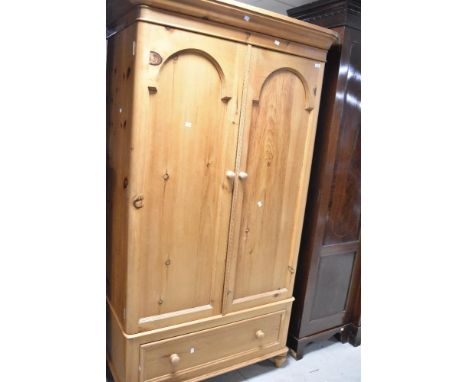 A natural pine single wardrobe, on single drawer base, width approx. 110cm