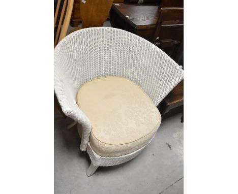A traditional Lloyd loom tub chair having upholstered seat