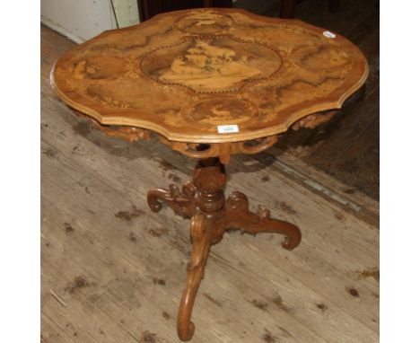 A Swiss style table, the shaped oval top inlaid stag, deer and mountain goats, on a carved tripod base, 70 cm wide