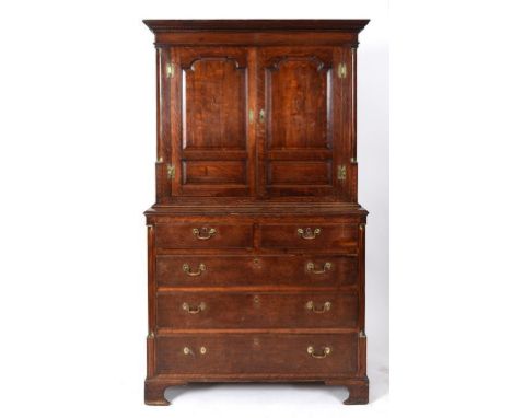 A housekeeper's style oak cupboard, the moulded and dentil cornice above a pair of panel doors inlaid shells, the base having