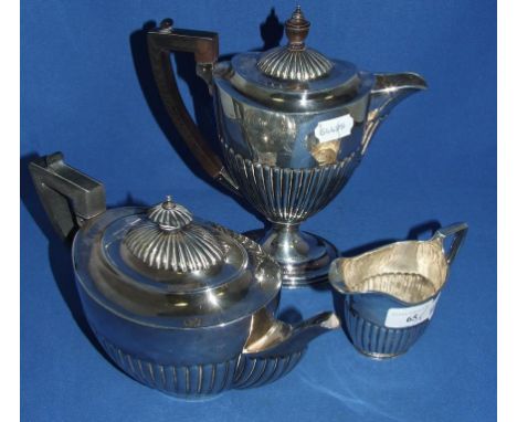 A silver three piece tea and coffee service, crested and engraved a motto, with reeded lower bodies, London 1891 (marks rubbe