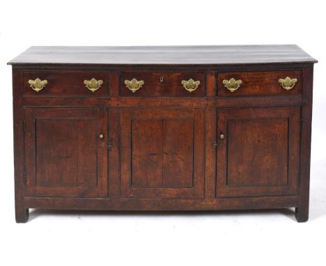 A 19th century oak dresser base, having three frieze drawers above three panel doors, on stile legs, 164 cm wide Condition re