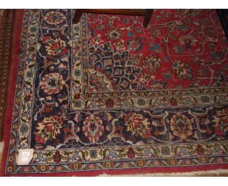 A Persian medallion carpet, with stylised floral motifs on a red ground, within a multi border, 390 x 280 cm