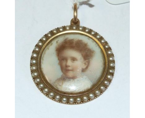 A portrait miniature, of a young child, watercolour, 2 cm diameter, mounted as a pendant, within a seed pearl frame